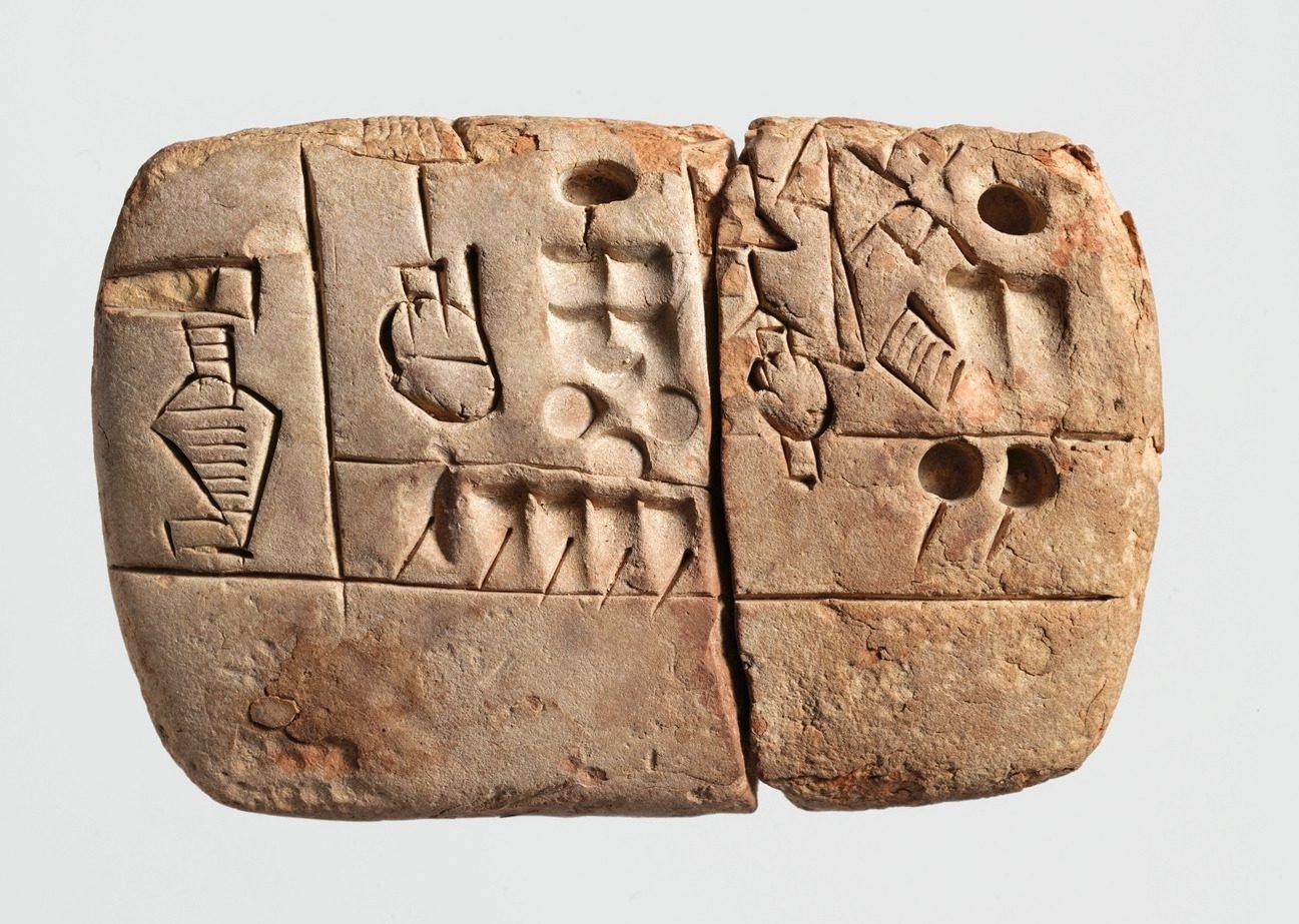 A clay tablet from Uruk, about 3100–2900 BC, small enough to sit in your palm, now in the Metropolitan Museum of Art. The signs are drawn, not yet pressed in wedges: a jar, a head, and rows of circles and notches that are numbers. It is an account of malt and barley handed out by a large temple — not a poem, not a prayer. The oldest writing in the world is a grain ledger. A tablet like this is how a city of forty thousand could prove who owned what.